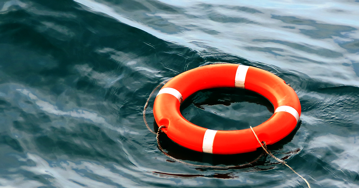 orange life preserver floating on dark colored water