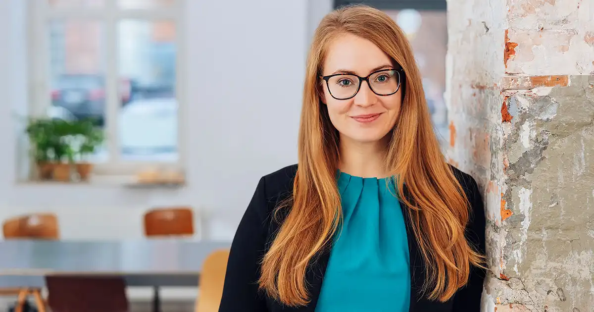 Caucasian woman with red hair and glasses smiling 