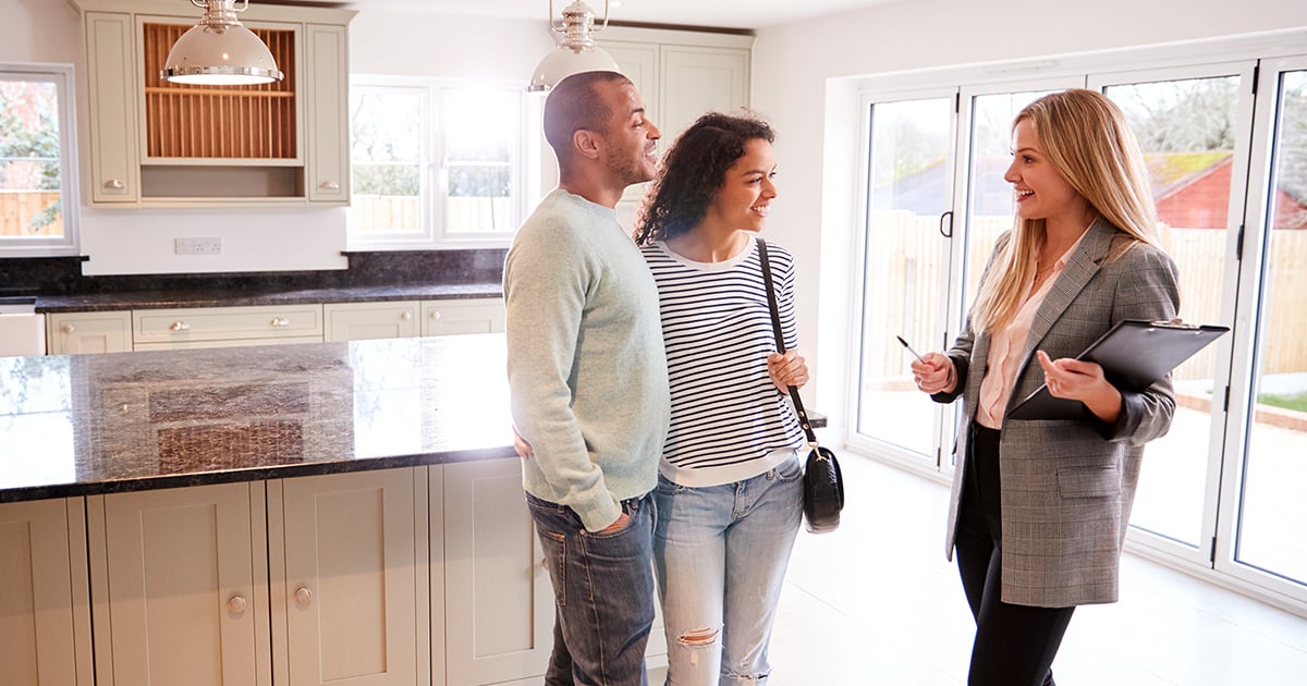 Couple shopping for a home meets with a real estate agent