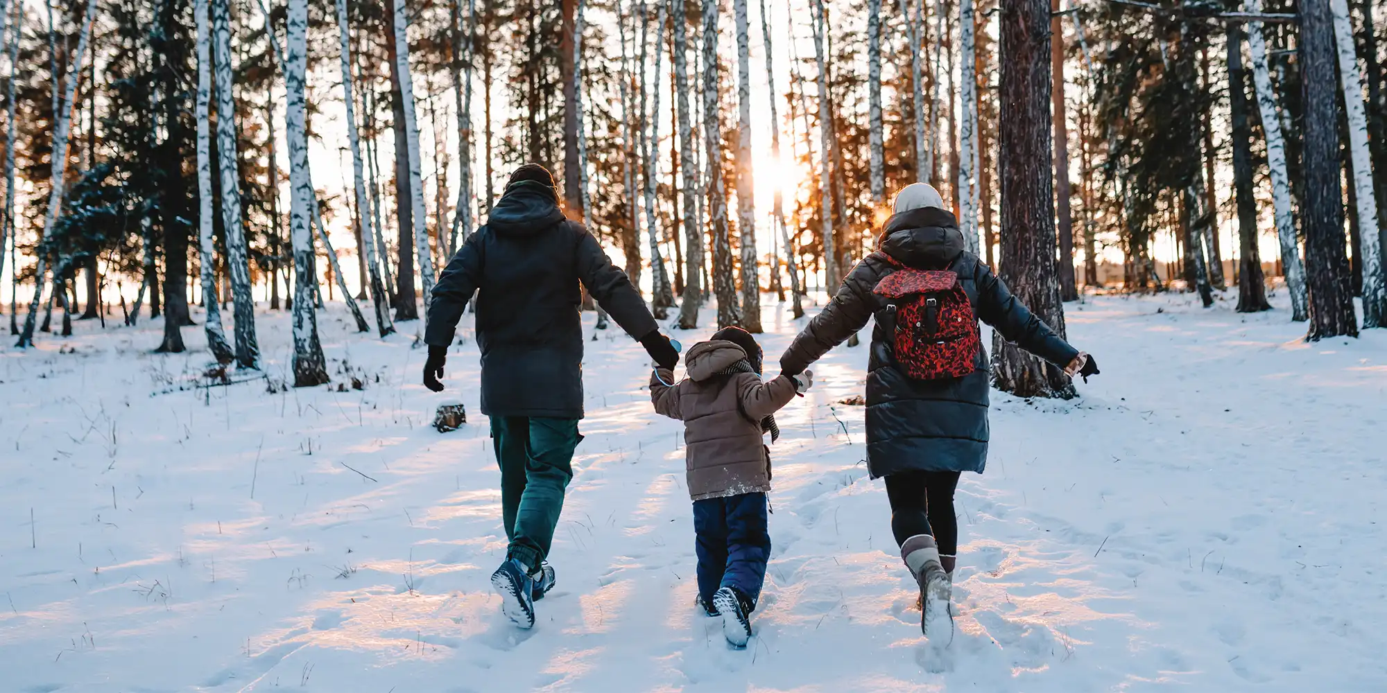 family walking in the snow together