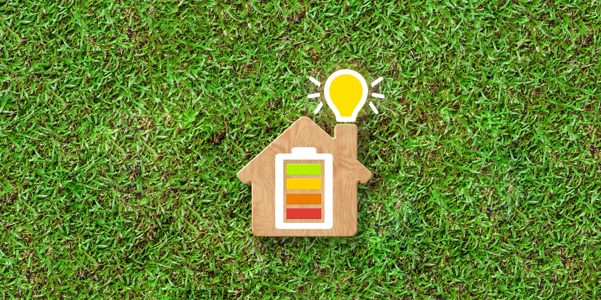 wooden house with battery illustration on the front laying on green grassy area