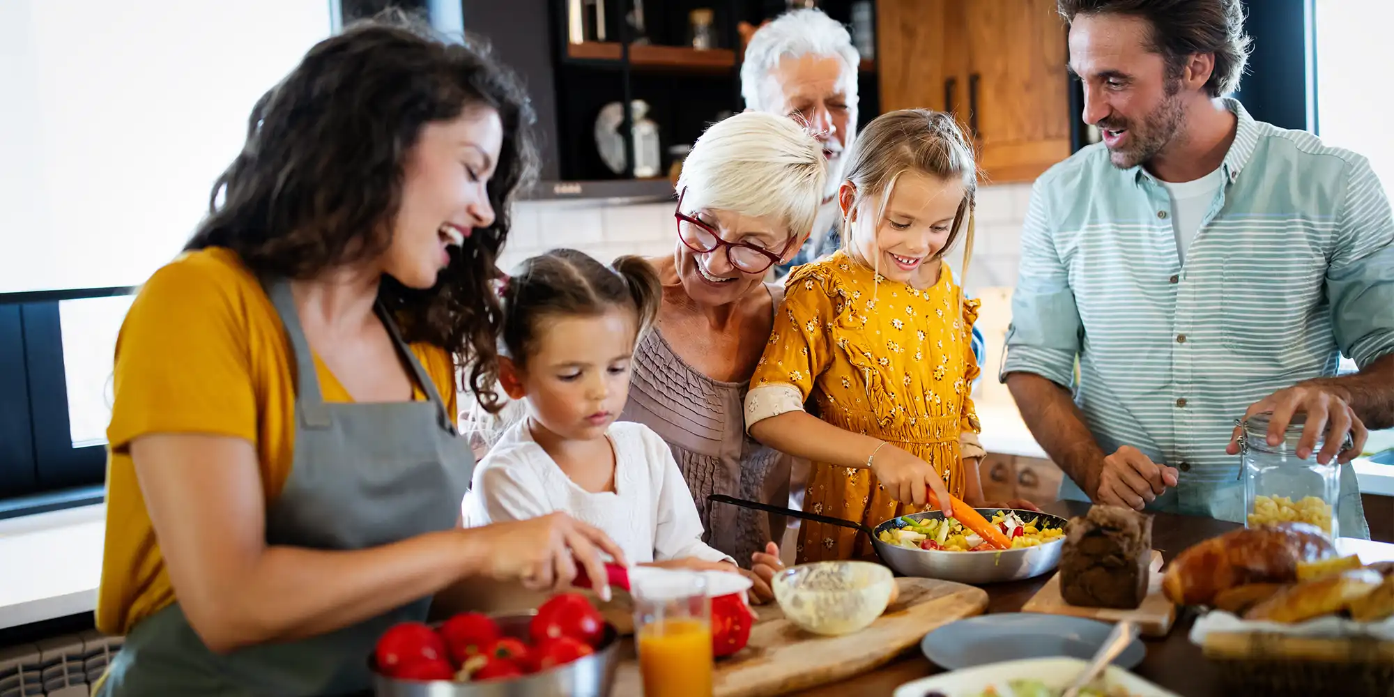 multigeneration family cooking in the kitchen together chopping vegetables
