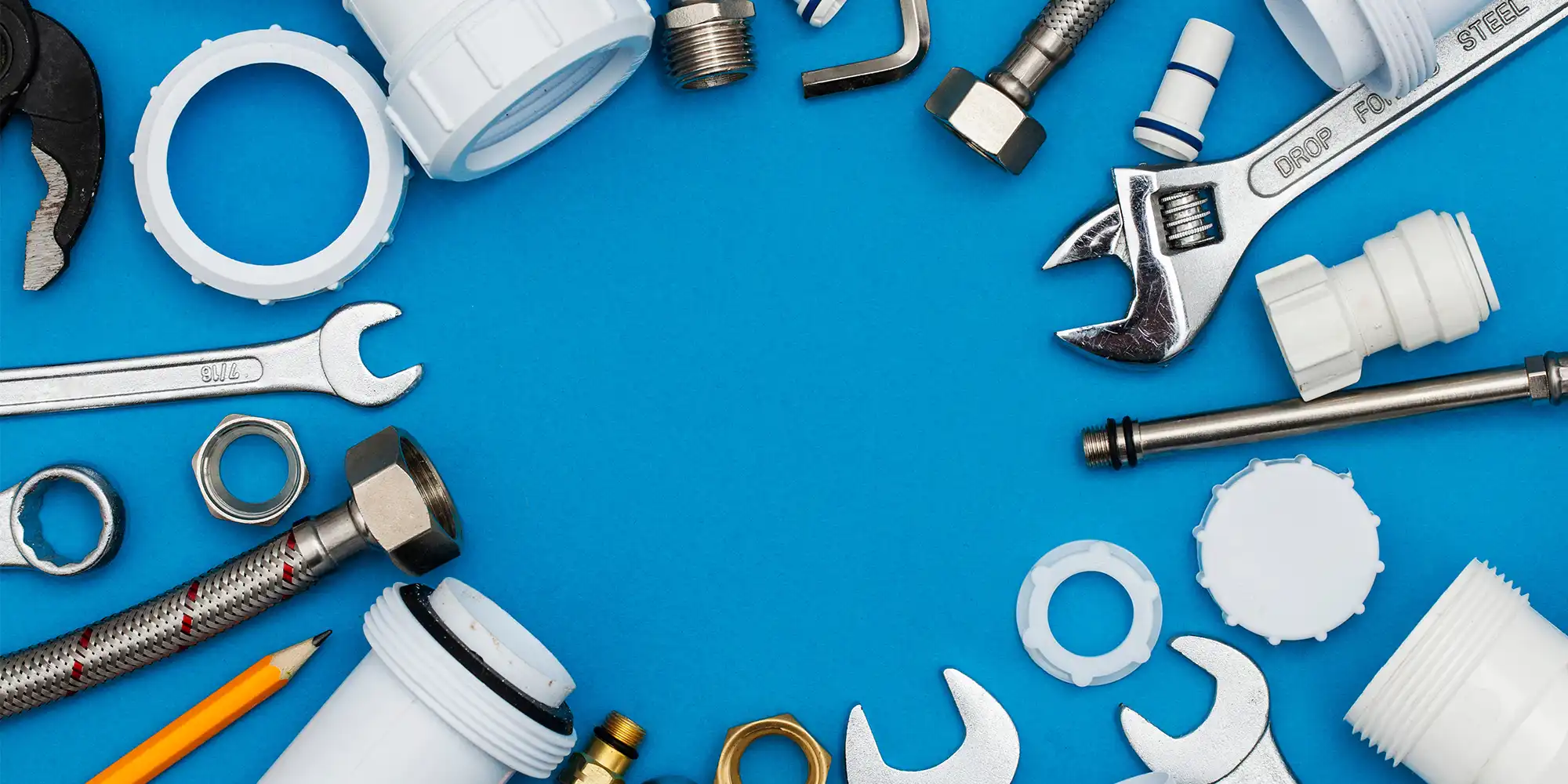 plumbing tools laying in a circle on a bright blue surface
