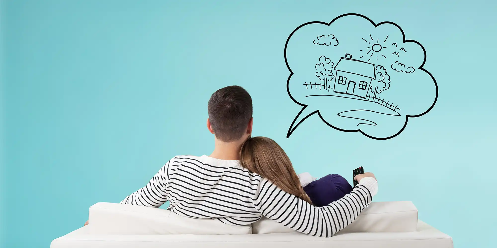 young caucasian couple sitting on couch facing away while talking about homes via an illustration above them of a house