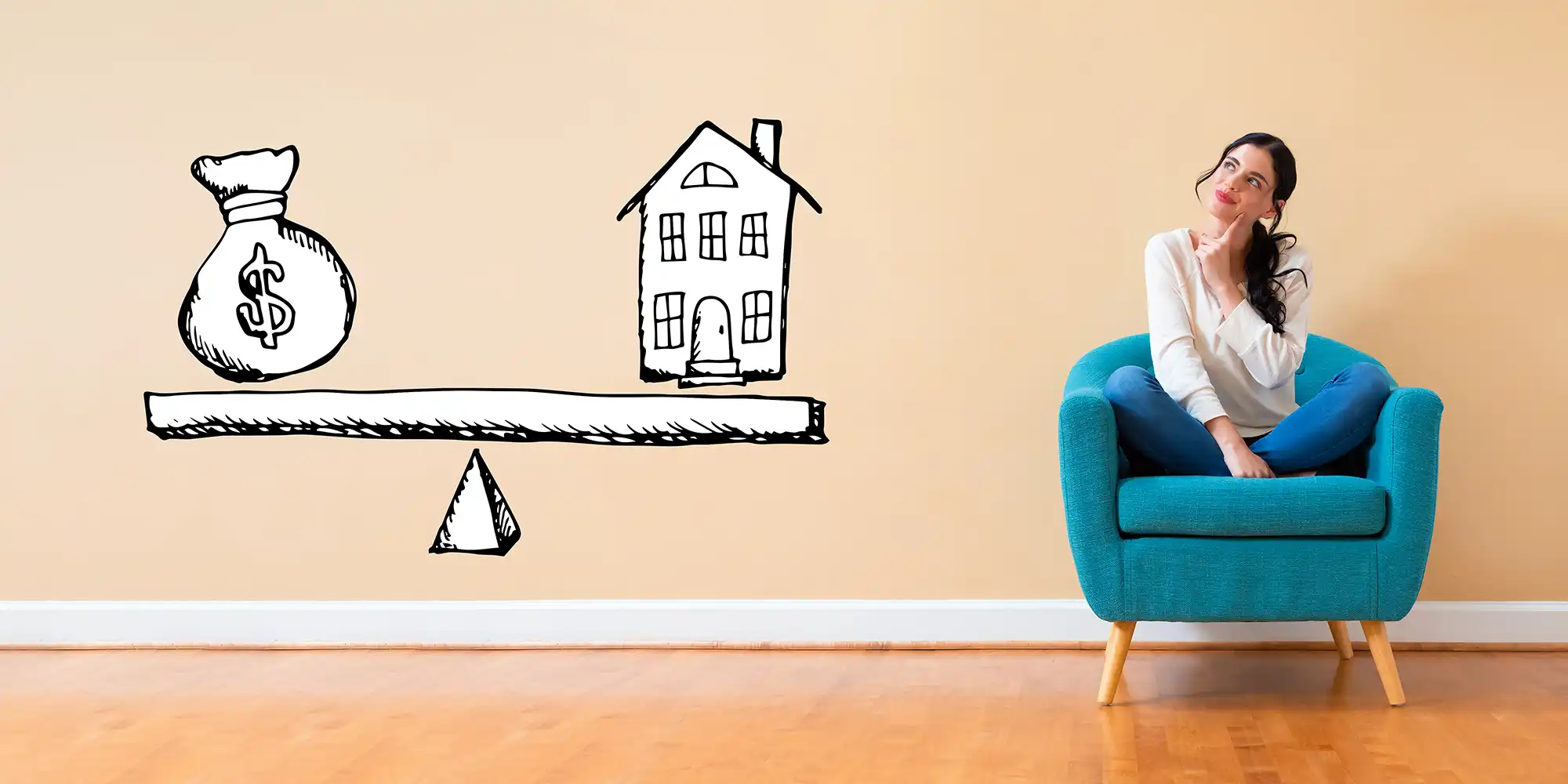 young woman with long dark hair sitting on a teal chair in a peach colored room is daydreaming about an illustration of a scale weighing money versus a house