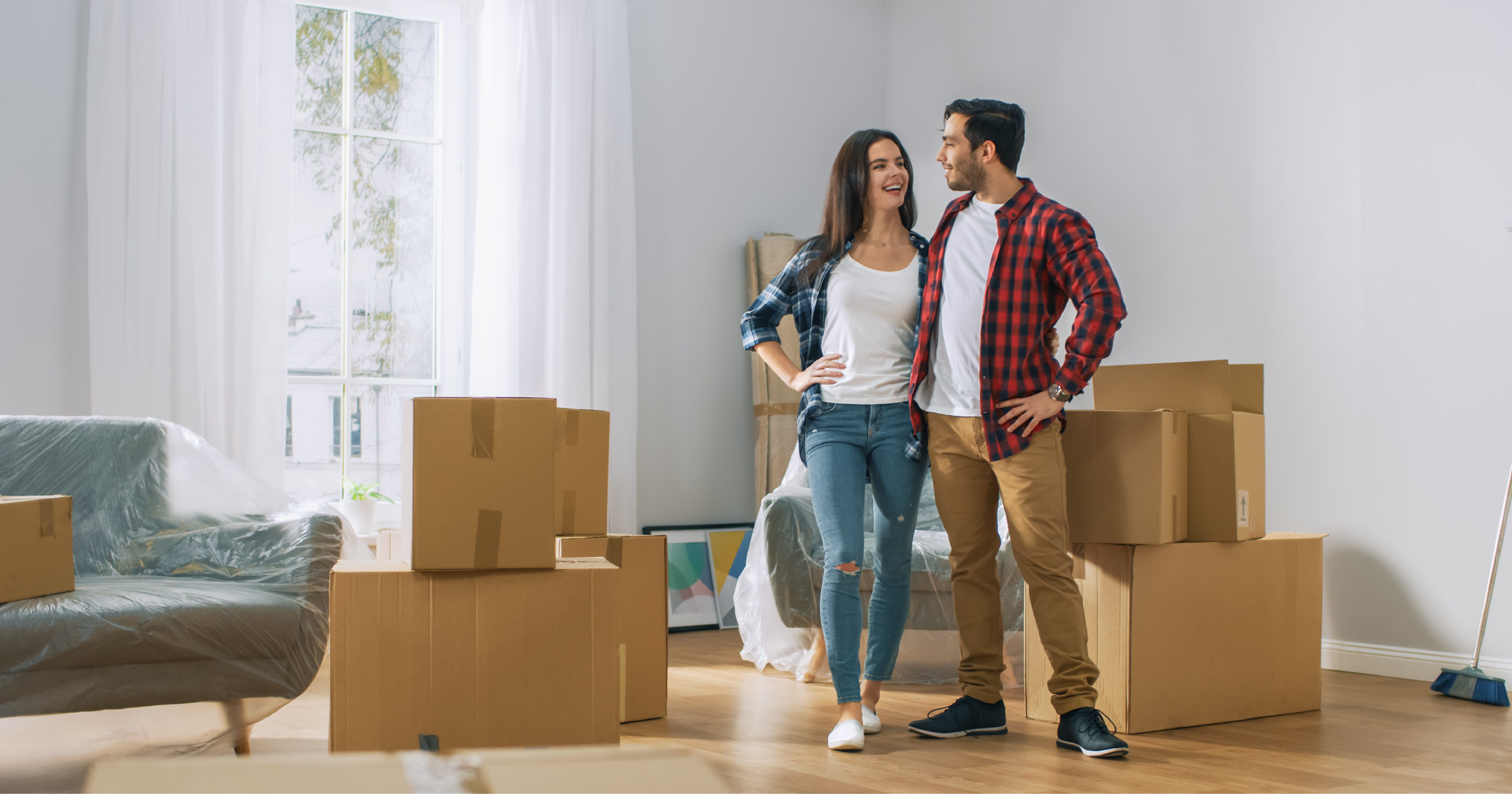 Happy new homeowners surrounded by boxes