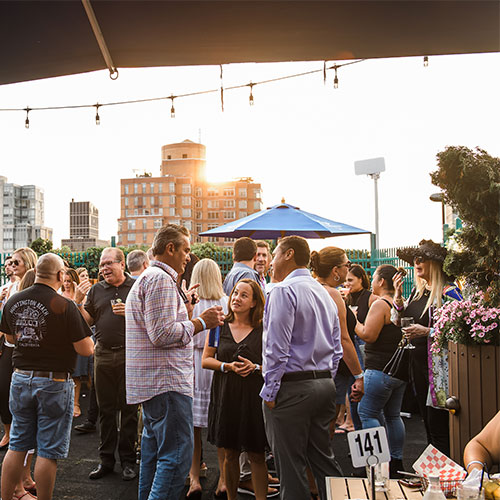 employees enjoying drinks during sunset on a city rooftop