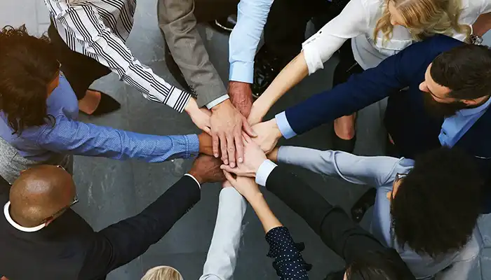 people with hands in the middle during a team huddle