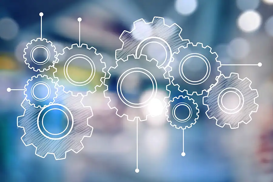 white gears illustration on top of blurred colorful background