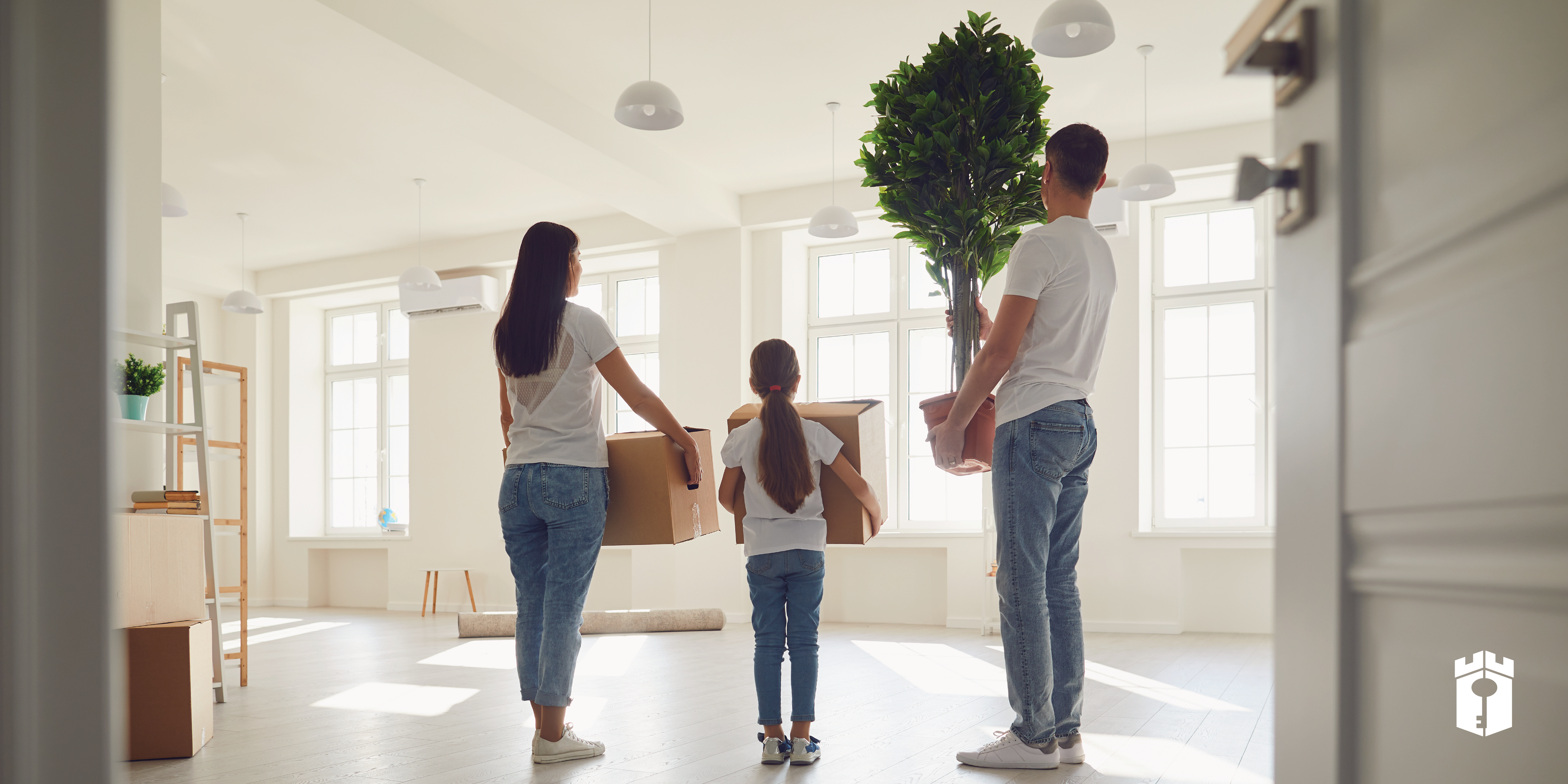 family holding their belongings in boxes while standing in new home