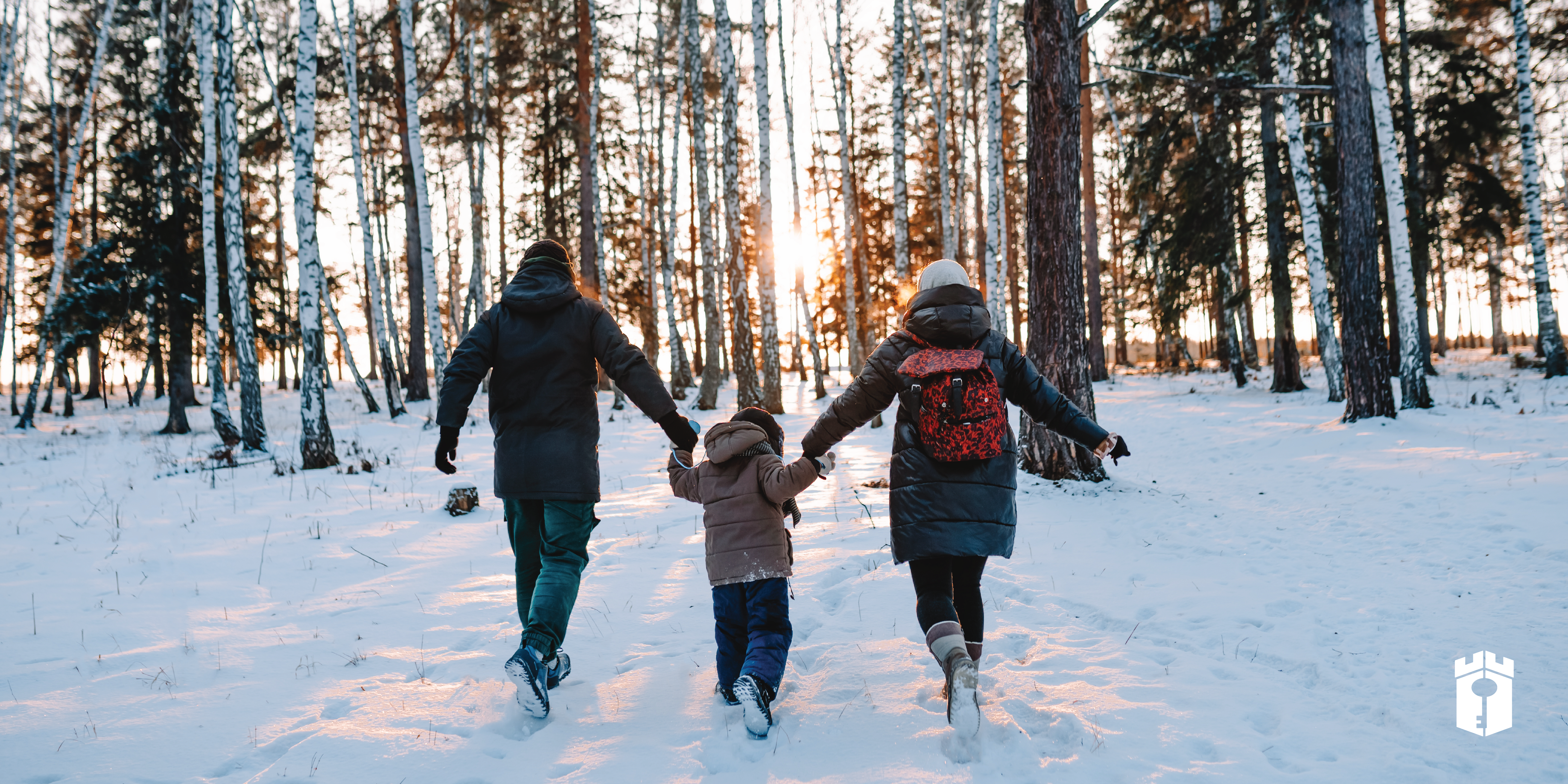 family walking in the snow together